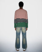 Person wearing a striped long sleeve t-shirt and jeans on a white background