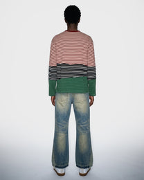Person wearing a striped long sleeve t-shirt and jeans on a white background